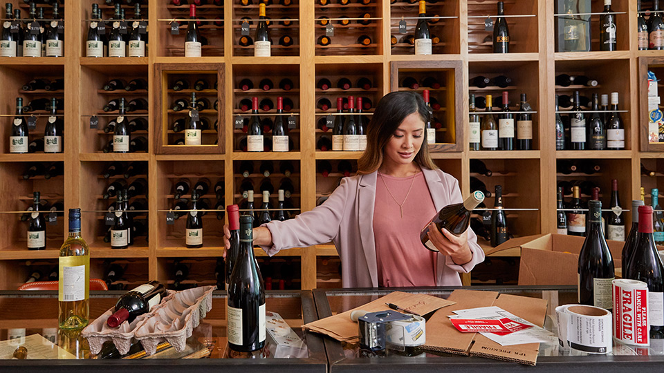Woman looking at wine bottle in retail setting