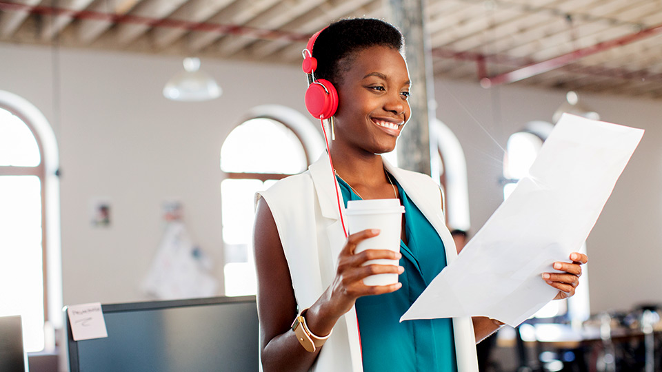 Woman with headphones reviewing a document