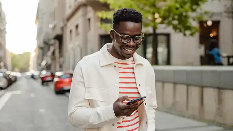 Person is outside using their cellphone to sign into U-P-S.com , in order to hold a delivery.